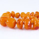 A graduated string of polished butterscotch amber beads, largest bead 23.6mm across, necklace length