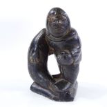 An Inuit carved stone man with a fish, signed Tomassie Tookalook, height 12cm