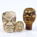 A Chinese carved and stained ivory mask design parasol handle, with inset shell eyes, height 4cm,