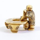 A Japanese Meiji period ivory carving of a boy with a hibachi table, height 32mm