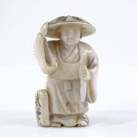 A Japanese Meiji period ivory netsuke, in the form of a figure wearing a hat, signed, height 5cm