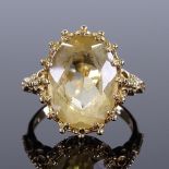 A 9ct gold oval citrine dress ring, with ornate relief shoulders and pierced bridge, setting