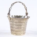 A small silver swing-handled pail bucket, with pierced handle and banded body, by William Comyns &