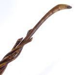 An African carved wood walking stick with entwined snakes