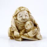 A Japanese carved ivory netsuke, in the form of a figure with a boy, signed, height 3cm