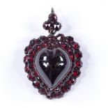 A Victorian cabochon heart-shaped garnet pendant, surrounded by faceted garnets, unmarked garnet