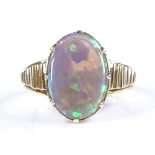 An unmarked gold black opal panel ring, with open-work bridge and ribbed shoulders, unmarked