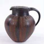 A handmade Studio pottery jug, dark brown glaze with incised decoration, monogram EK, height 16.5cm