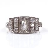 An Art Deco unmarked gold diamond cluster panel ring, with central oval-cut diamond and stepped