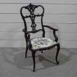 A late Victorian carved and pierced mahogany framed elbow chair