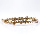A Victorian 9ct gold split-pearl heart and floral hinged bangle, setting height 11.9mm, internal