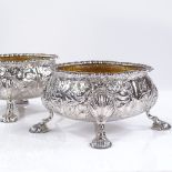 A pair of George IV heavy gauge silver salts, with relief embossed floral decoration, hoof feet