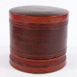 A Burmese red lacquer betel nut cylindrical box, circa 1900, with painted geometric decoration,