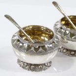 A pair of Victorian circular silver salts, with beaded rim, textured neck, and gilt interiors, by