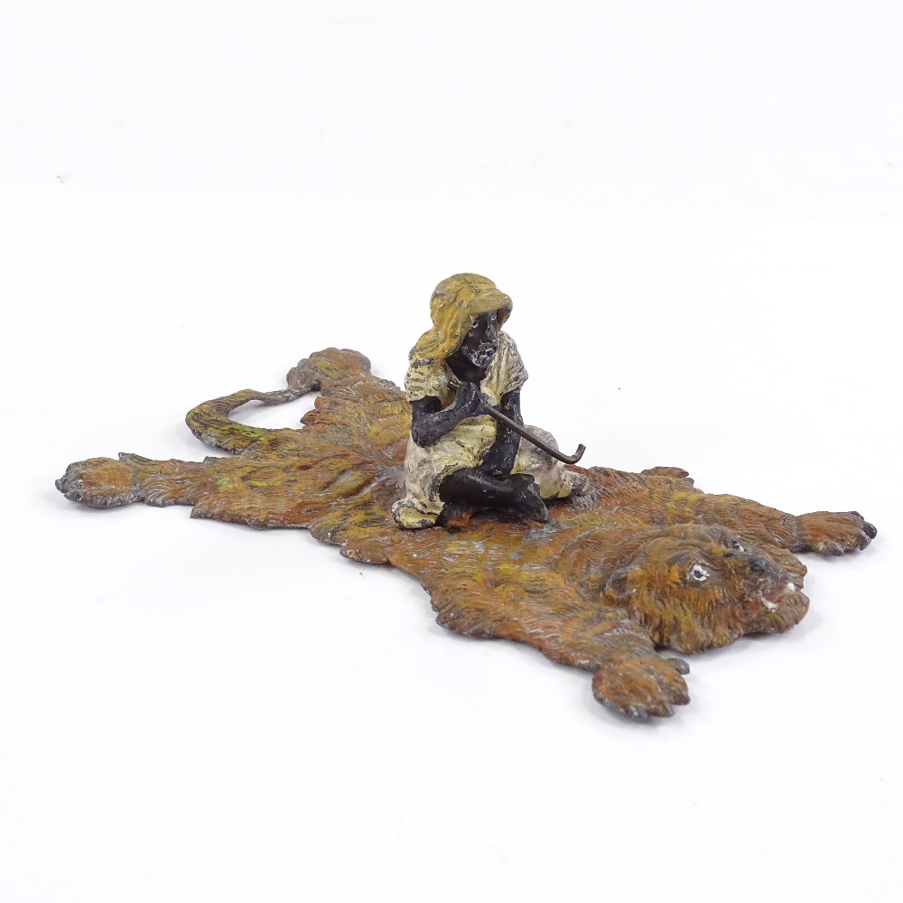 A cold-painted metal Arab on a tiger-skin rug, length 12cm - Image 2 of 3