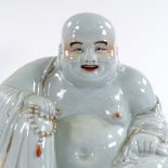 A Chinese white glaze and gilded porcelain seated Buddha, height 26cm