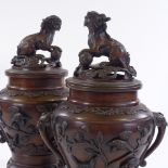 A pair of Oriental patinated bronze vases and covers, with Dog of Fo knops and bird decorated relief