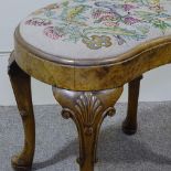 A Queen Anne style walnut kidney-shaped dressing stool, with needlework seat and shell carved