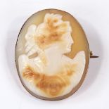 A relief carved cameo shell panel brooch, depicting Classical female portrait, in unmarked gold