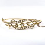 An Edwardian 15ct gold split-pearl floral hinged bangle, setting height 15.2mm, internal diameter