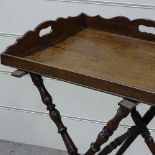 A Georgian mahogany butler's tray, with shaped gallery, on turned folding base, 2' x 19.5"