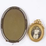 A small Edwardian oval photo frame, height 13cm, and a gilt-metal photo frame with ribbon top,