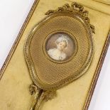 A French early 20th century gilt-brass hand mirror, circa 1900 - 1910, having an inset miniature