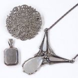 A stylised mother-of-pearl and silver pendant necklace, a pierced floral silver brooch, and a silver