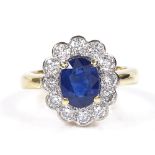 An 18ct gold sapphire and diamond cluster ring, oval-cut sapphire approx 1.59ct, total diamond