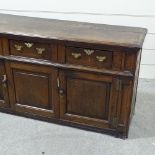 An 18th century oak dresser base, with 3 frieze drawers and panelled cupboards under, width 6',