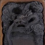 A large Chinese dragon relief design ink stone in stained wood case, case length 42cm