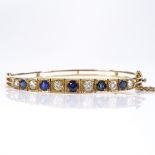 A 9ct gold graduated sapphire and diamond hinged bangle, with openwork settings, largest diamond