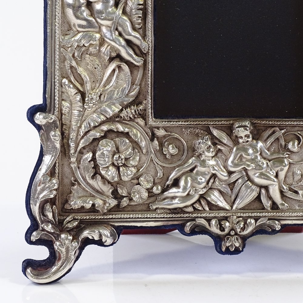 A modern Britannia standard silver-fronted photo frame, with high relief flower and cherub