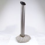 A handmade stainless steel cylinder floor vase, in rough stone base, height 60cm