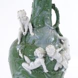 A Continental porcelain narrow-necked vase, decorated in high relief with playing cherubs, circa