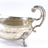 A George V silver sauce boat, with gadrooned rim and foliate scrollwork handle, by Mappin & Webb,