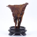 A Chinese rhino horn libation cup, 18th or 19th century, carved all over with lily flower relief