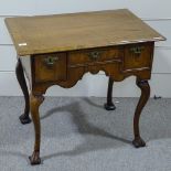 An 18th century walnut lowboy with feather-banded top, 3 frieze drawers with shaped apron and