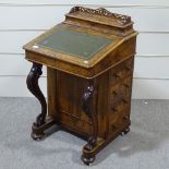 A Victorian walnut Davenport with carved cabriole supports
