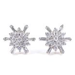 A pair of 9ct gold diamond cluster snowflake earrings, set with round and baguette-cut diamonds,