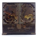 A Japanese Meiji period gilded and lacquered table cabinet with eagle decorated panelled doors,