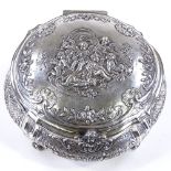 A large German circular silver box, with hinged lid, on scrolled acanthus leaf feet, relief embossed