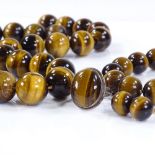 A suite of polished tiger's eye bead jewellery, including necklace, bracelet, earrings and ring,