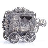 An unusual novelty silver plated miniature music box, in the form of a carriage, length 7cm