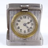 An Art Deco silver-cased travelling timepiece, engine turned case, with Arabic numerals and blued