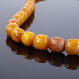 A string of polished graduated butterscotch amber beads, largest bead length 17.1mm, necklace length