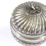 A Continental circular silver lidded box, with fluted decoration and cast silver floral knop,