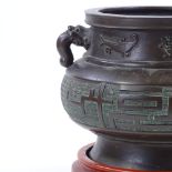 A Chinese bronze incense burner, cast dragon design handles, with relief decorated frieze, rim