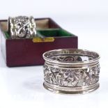 A pair of Edwardian Art Nouveau silver napkin rings, with pierced floral decoration, 1 by