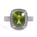 A 14ct rose gold peridot and diamond dress ring, with diamond set shoulders and bridge, setting